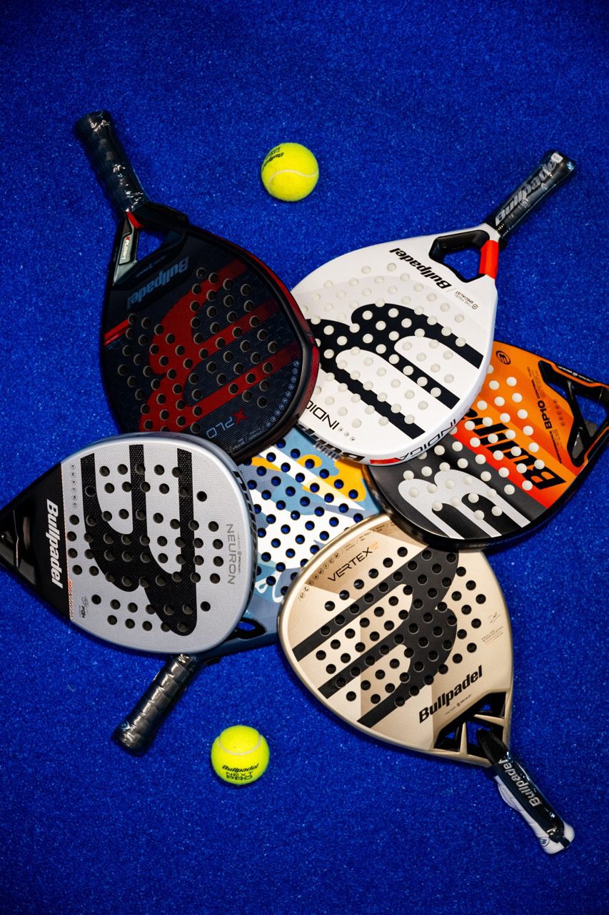 Raquettes de padel et balles disposées sur un fond bleu, Pro Shop ZE PADEL