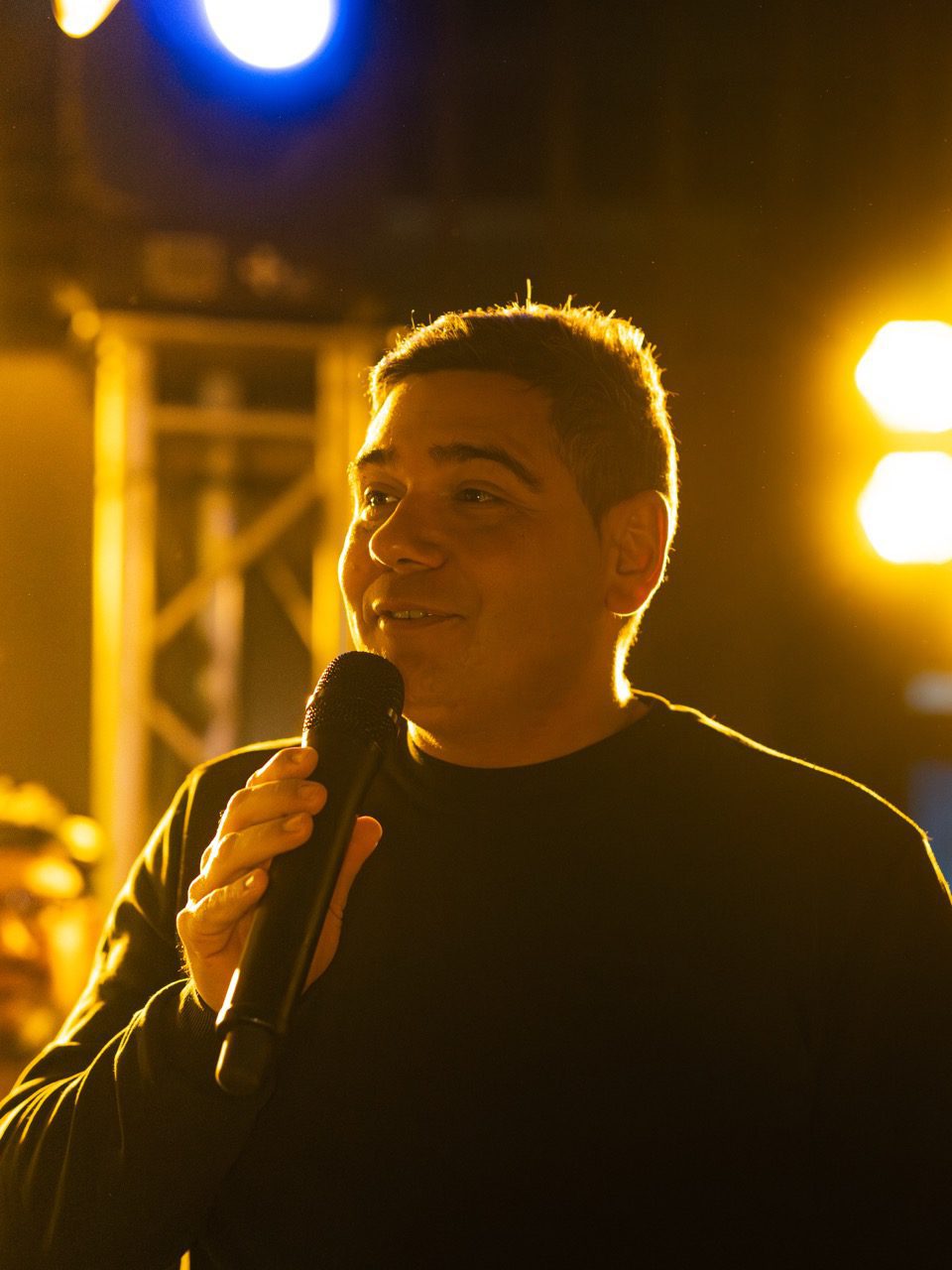 Chanteur au micro lors d'une soirée live au ZE PADEL Social Club