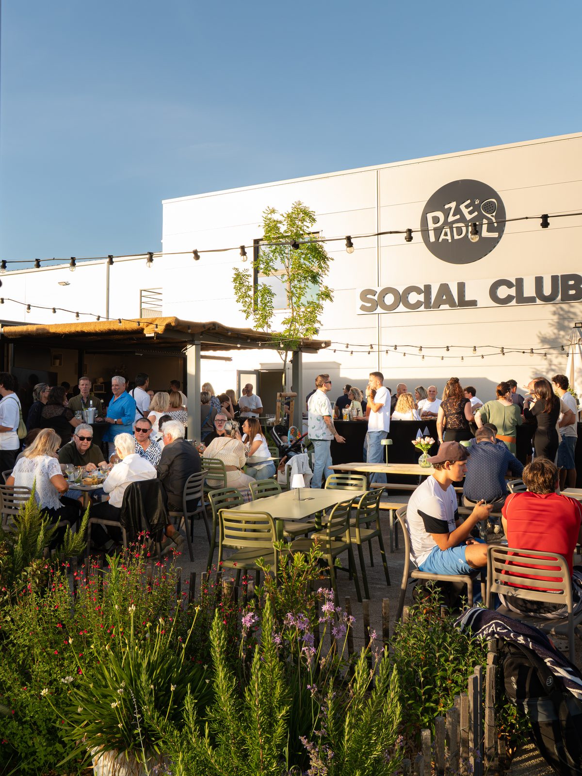 Public en soirée sur la terrasse du ZE PADEL Social Club